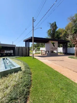 Vista externa de uma propriedade com gramado e paisagismo.