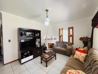 Sala de estar com sofá e rack de TV em ambiente claro.