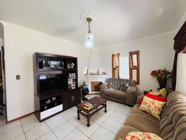 Sala de estar com sofá e rack de TV em ambiente claro.