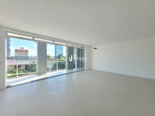 Uma sala de estar ampla com portas de vidro se abre para o exterior.