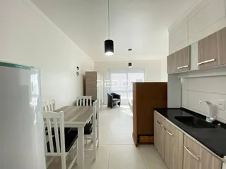Ambiente interno de uma sala de jantar e cozinha com piso de cerâmica.