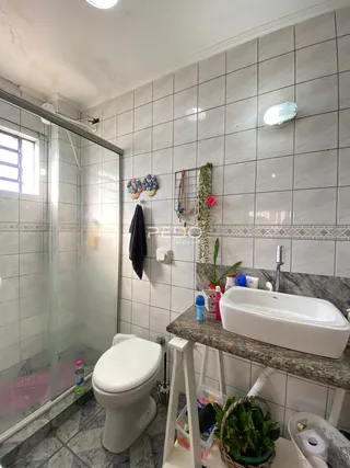 Foto de um banheiro com revestimento de azulejos brancos.