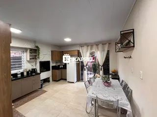 Sala de estar com móveis de madeira e uma mesa de jantar.