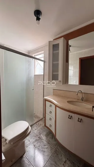 Foto de um banheiro interno com revestimento de piso e armário de madeira.