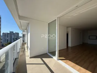 Sala de estar com piso de madeira e porta de vidro que dá para a varanda.
