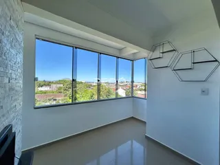 Sala ampla com grande janela oferecendo vista panorâmica da paisagem.