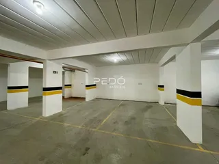 Espaço interno com paredes brancas e piso de concreto em uma edificação.