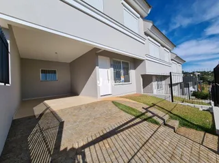Fachada de uma residência em Lajeado, Brasil com jardim e área pavimentada.