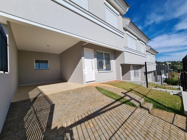 Fachada de uma residência em Lajeado, Brasil com jardim e área pavimentada.