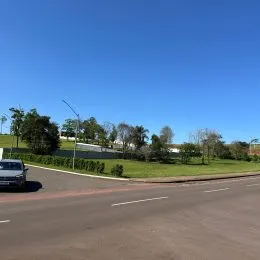 Vista da rua com vegetação ao fundo.