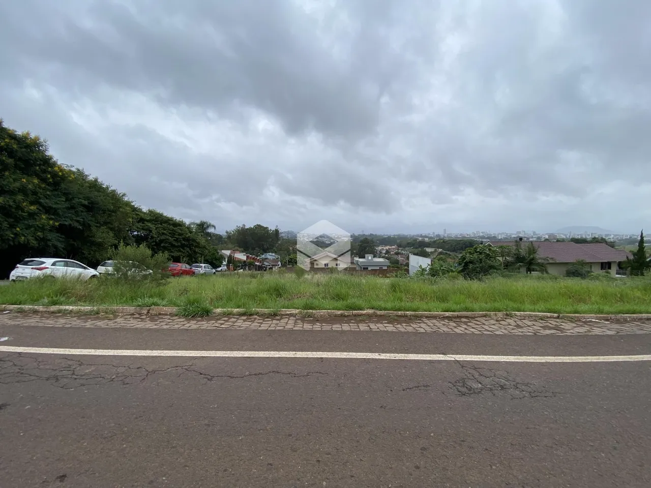 Vista externa de uma propriedade com vegetação ao fundo.