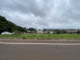 Vista externa de uma propriedade com vegetação ao fundo.