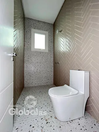 Foto de um banheiro com revestimento de azulejos brancos e cinzas.