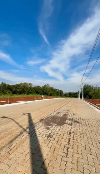 Vista de uma estrada pavimentada sob um céu azul com nuvens brancas.