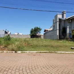 Vista externa de uma residência em Lajeado, Brasil, com gramado e vegetação à frente.