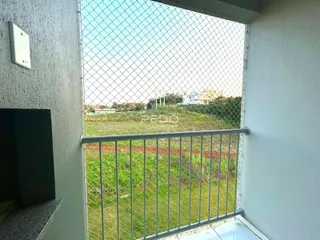 Vista de um campo verde através de uma cerca de arame.
