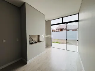 Interior de uma sala com piso de madeira clara e porta de vidro que dá para o quintal.