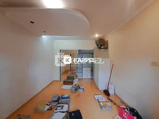 Vista interna de uma sala com piso de madeira e área de passagem.