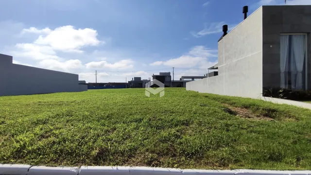 Vista externa de uma propriedade com gramado verde e um edifício moderno.