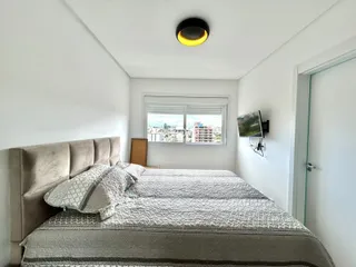 Quarto com cama e janela em um apartamento.