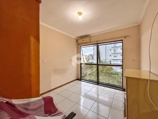 Sala de estar com piso de cerâmica e grande janela de vidro.