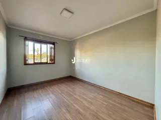 Sala de estar com piso de madeira e janela.