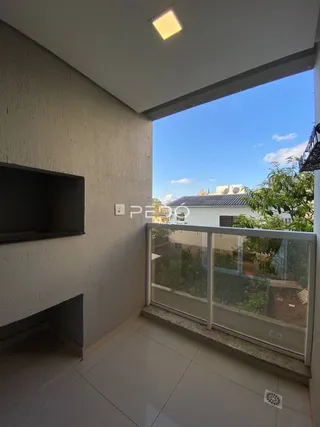 Vista de uma varanda com grade de vidro em uma residência.