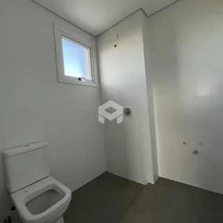 Banheiro com janela e piso escuro.