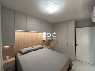 Quarto com cabeceira e armários em um ambiente claro.