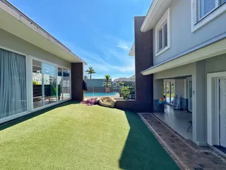 Vista externa de uma residência com jardim e piscina.