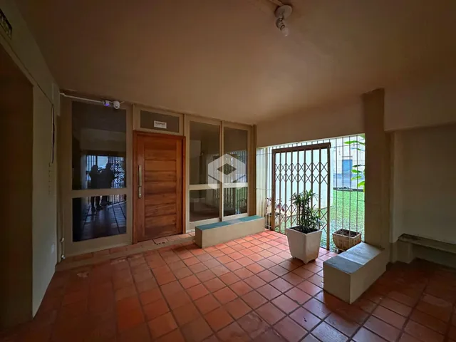 Sala de estar com piso de cerâmica avermelhada e portas de vidro.