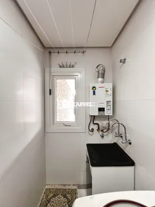 Foto interna de um banheiro com janela e instalação de torneira.