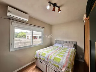 Quarto com janela e cama de madeira em um imóvel no Brasil.
