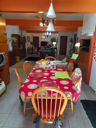 Mesa de jantar de madeira com cadeiras em uma sala de jantar.
