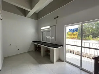 Interior de uma sala com piso claro e uma bancada longa.