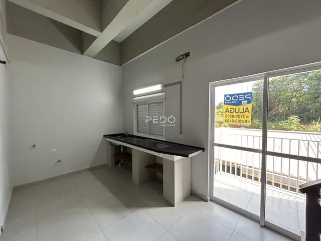 Interior de uma sala com piso claro e uma bancada longa.