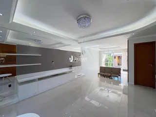 Sala de estar ampla com piso de porcelanato claro e decoração moderna.
