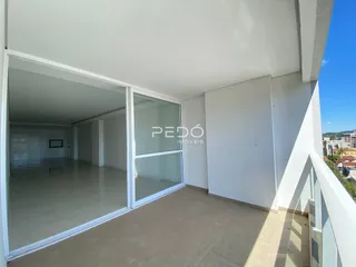 Vista de um ambiente interno com portas de vidro que dão acesso a uma área externa.
