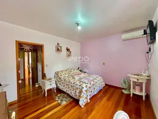 Quarto com piso de madeira e cama em um imóvel no Brasil.