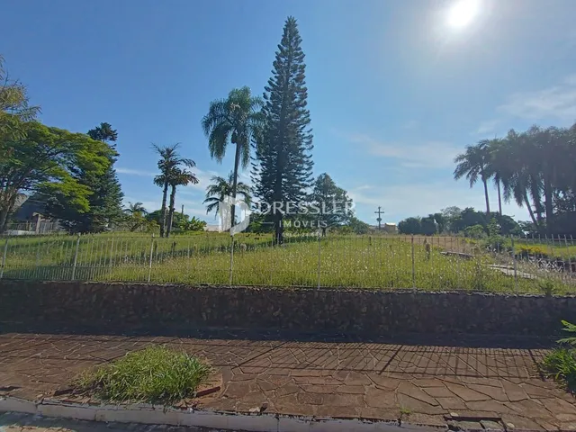 Vista externa da propriedade com campo gramado e muro de pedra.