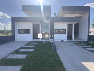 Fachada de uma casa moderna em Lajeado, Brasil, apresentando um design contemporâneo em branco e cinza.