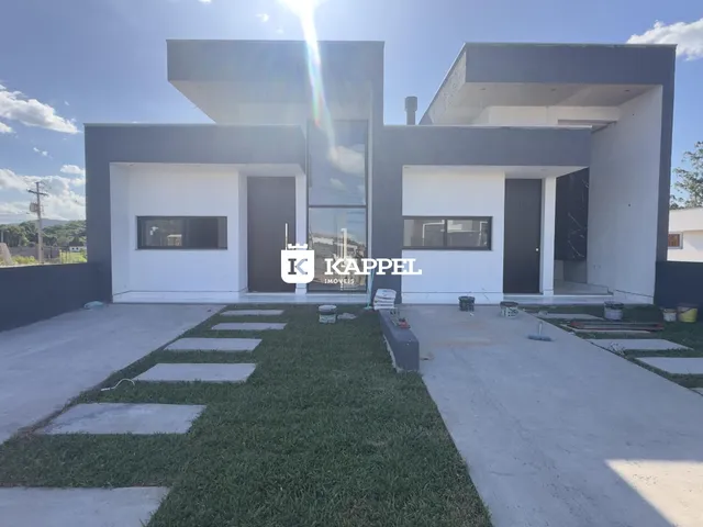 Fachada de uma casa moderna em Lajeado, Brasil, apresentando um design contemporâneo em branco e cinza.