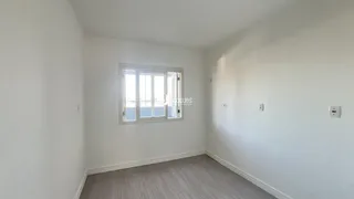 Vista interna de um cômodo com paredes brancas e piso de madeira clara.