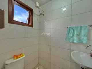 Foto de um banheiro com paredes revestidas de azulejos brancos.