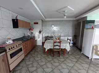 Interior de uma sala com piso de cerâmica e móveis de madeira.