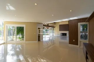 Ambiente interno amplo com piso claro e portas de vidro que dão acesso ao exterior.