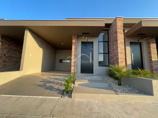 Fachada moderna de uma residência em Lajeado, Brasil, com área coberta e paisagismo.