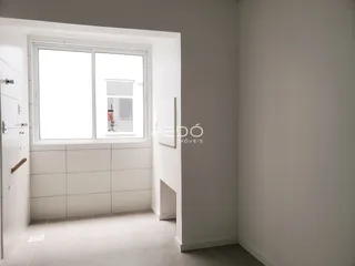 Vista interna de um corredor com porta e janela em uma residência.