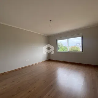 Foto de uma sala com piso de madeira clara e janela.