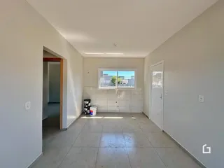 Hall de entrada com piso de cerâmica e janela mostrando a vista externa.